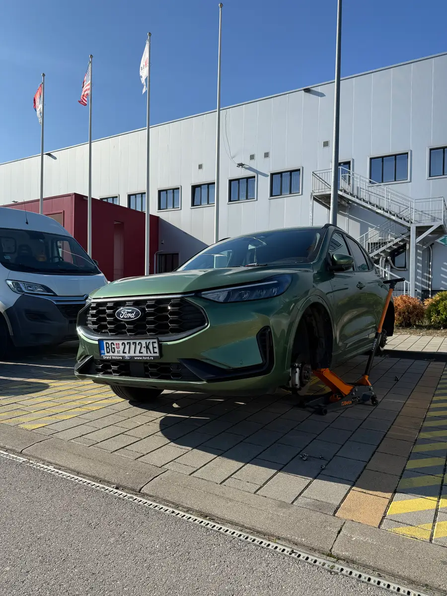 Ford podignut dizalicom radi pristupa pneumatiku na parkingu