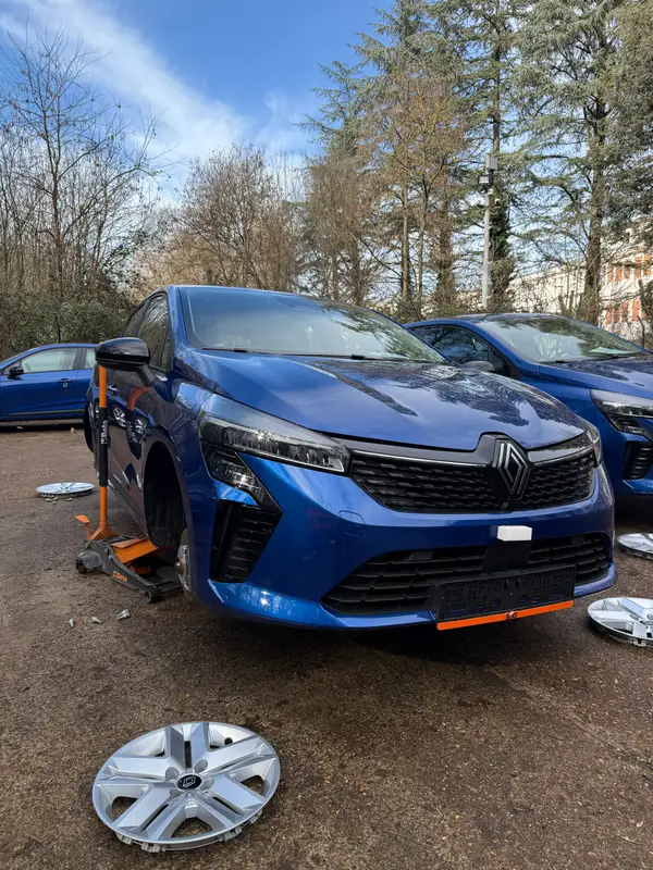 Renault podignut dizalicom tokom zamene točka na otvorenom parkingu